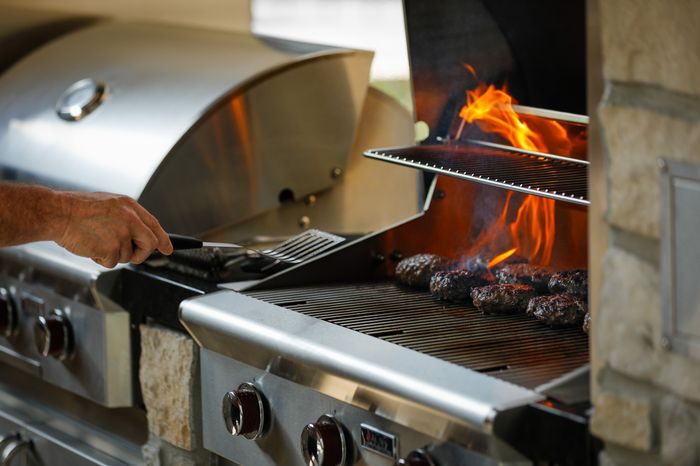 Residents enjoying the outdoor kitchen and gas grill at the Grilling Lounge in Wheatfield Village Apartments, Topeka, KS. Experience the ultimate in outdoor courtyard amenities.