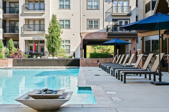 Resort Style Pool with Lounge Seating and Umbrella Landscape - A resort-style pool surrounded by comfortable lounge seating and umbrellas, creating a perfect setting for leisure and enjoyment.