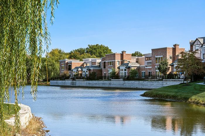 Mission Farms Pond Showcasing Exterior of 2 and 3 Bedroom Townhomes - A picturesque view of Mission Farms Pond, highlighting the exterior of the 2 and 3 bedroom townhomes.