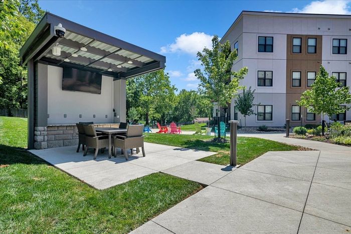Relaxing Courtyard Oasis - Sixty16 Apartments Shawnee, KS: Courtyard view of Sixty16 Apartments, a tranquil oasis with lush greenery and seating areas for relaxation in Shawnee, KS.