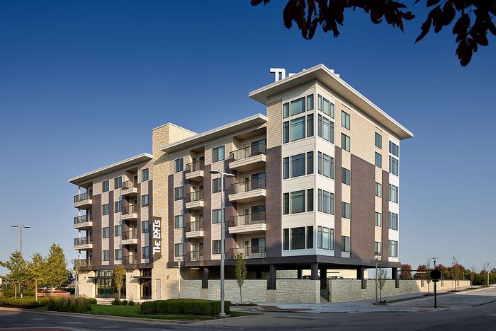 Four-story apartment building at The Lofts at City Center with balconies" Caption: "Spacious balconies and modern architecture
