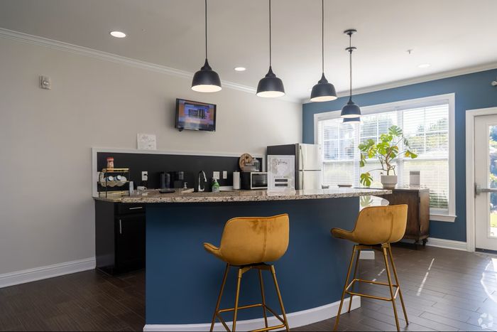 Bright and modern kitchen with sleek marble countertops, stylish pendant lighting, and cozy seating at the island bar.