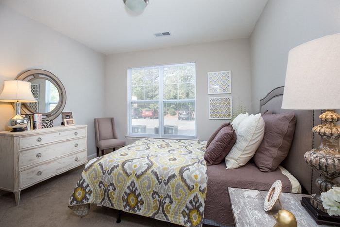 Elegant bedroom with plush bedding, stylish decor, and ample natural light, perfect for relaxing and unwinding.