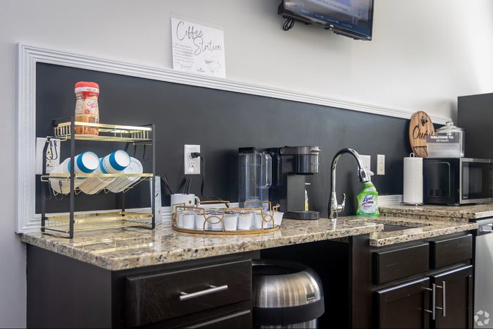 Chic granite-topped coffee station with Keurig machine, stylish mug rack, and assortment of pods for a cozy apartment refreshment area.