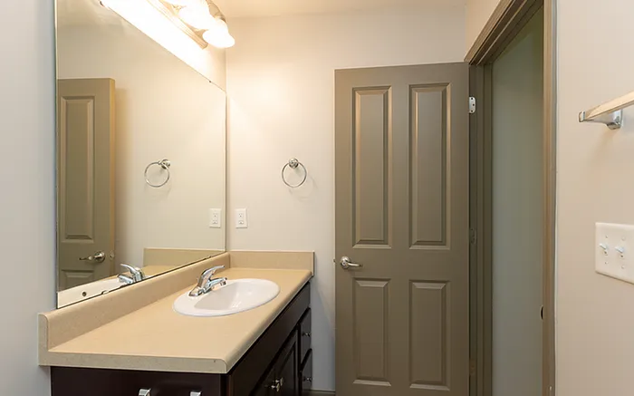 Elegant bathroom featuring a sleek vanity, modern sink, and ample mirror space for a contemporary look.