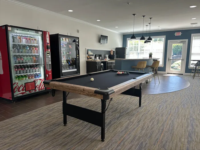 Chic recreational space with a pool table, modern snack vending area, and stylish seating for ultimate relaxation.