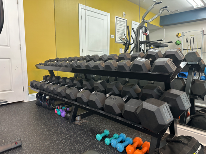 Modern fitness center with a wide range of dumbbells and vibrant kettlebells, ideal for an energetic workout experience.