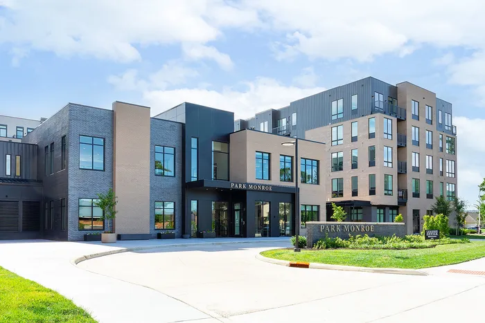 Modern apartment complex with sleek architectural design, featuring large windows and landscaped surroundings at Park Monroe.