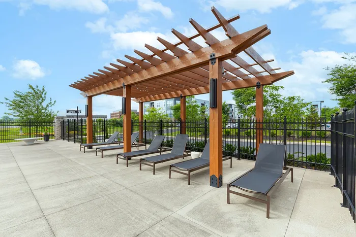 Inviting outdoor space with chic pergola and modern lounge chairs, perfect for relaxation and entertaining.