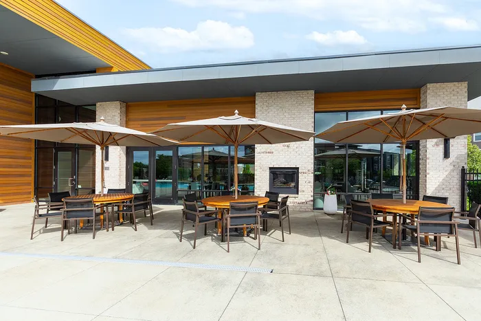 Elegant patio area with modern furniture and large umbrellas, perfect for outdoor dining and relaxation.