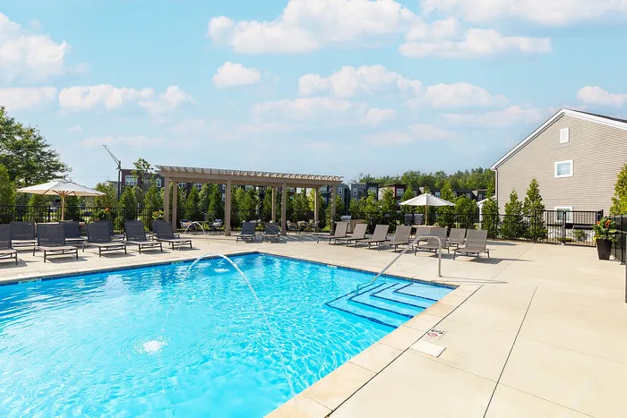 Refreshing outdoor pool area with elegant sun loungers, surrounded by scenic greenery and modern amenities.
