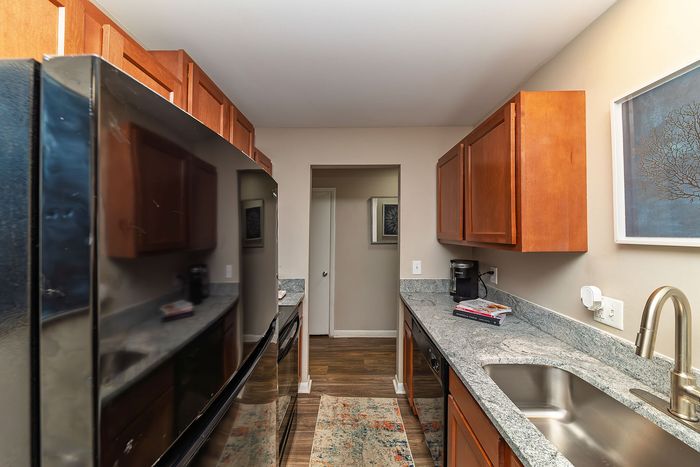 Modern kitchen with sleek stainless steel appliances, elegant granite countertops, and warm cabinetry.