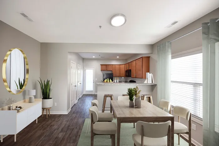 Bright, open-concept dining area with modern furnishings and adjacent kitchen featuring wooden cabinetry.