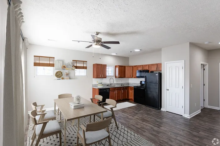 Bright and airy open-concept living space with a modern kitchen featuring wooden cabinets and a dining area.