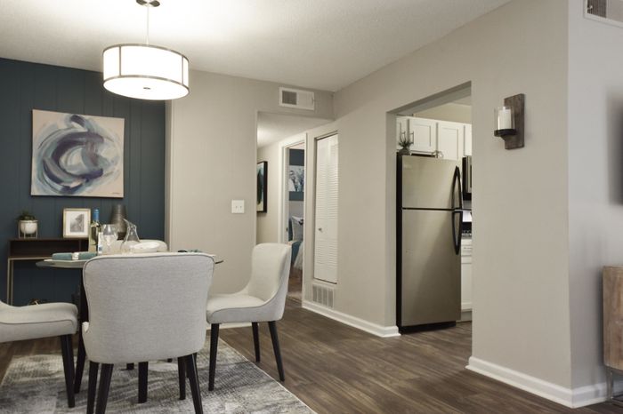 Stylish dining area with contemporary art, modern lighting, and open access to a sleek kitchen.
