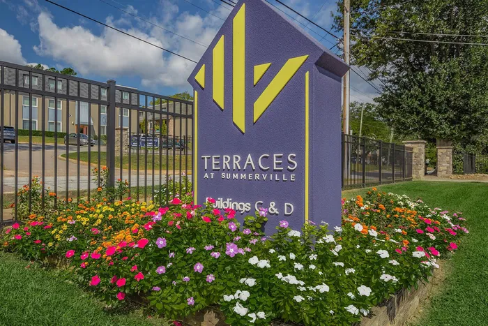 Vibrant entrance sign for Terraces at Summerville with colorful flowers.