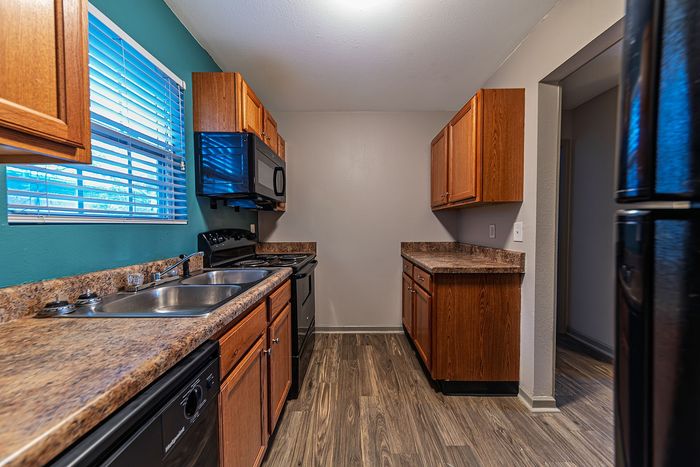 Modern kitchen with wooden cabinets, stainless steel appliances, and sleek countertops.