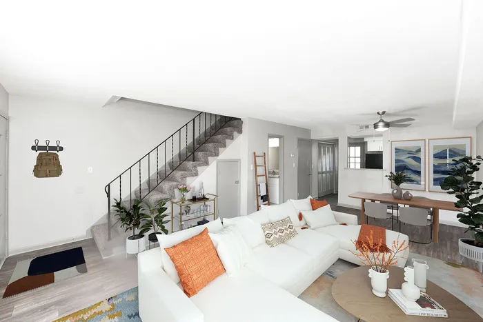 Stylish open-plan living room with white sectional sofa and dining area.