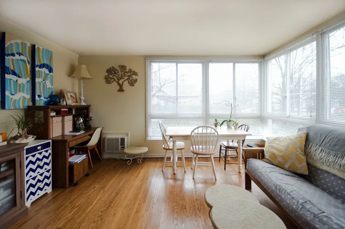 Inviting living area with large windows, cozy seating, and a dining table overlooking the outdoors.