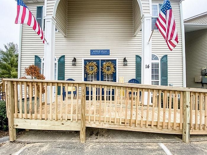 Charming entrance to a leasing office with decorative wreaths and American flags.