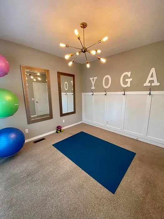 Inviting yoga room with vibrant equipment and elegant lighting.
