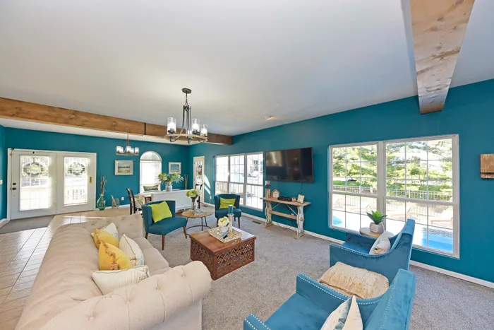 Cozy living room with elegant blue walls, rustic wooden beams, and plush seating area.
