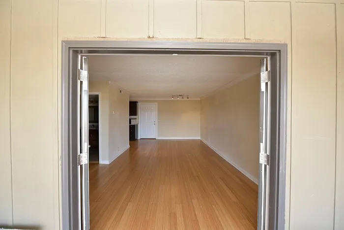 Inviting open space with polished wooden flooring and neutral walls, perfect for modern living.