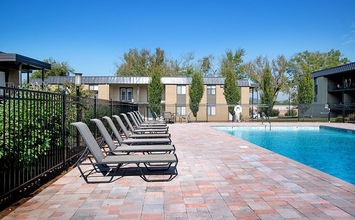 Inviting outdoor pool area with elegant lounge chairs lined up on a sunlit patio.