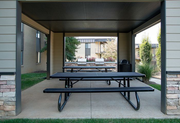 Inviting covered pavilion with picnic tables and grills, perfect for outdoor gatherings.