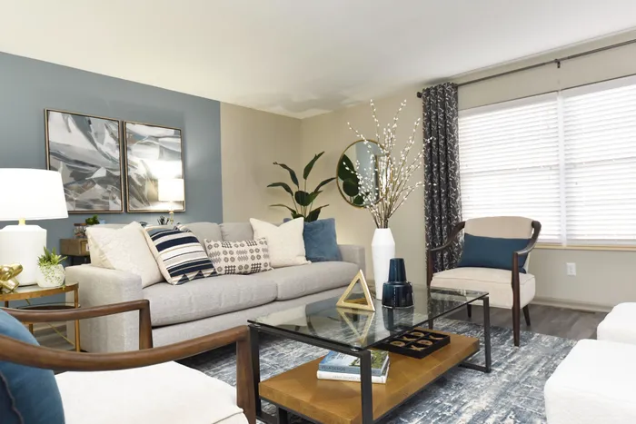 Bright and modern living room with stylish decor, featuring a cozy sofa, accent chairs, and artistic wall pieces.