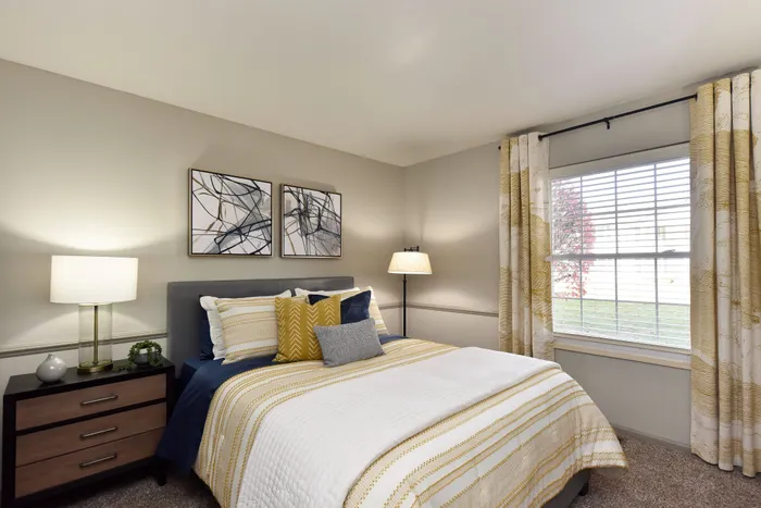 Inviting bedroom with modern decor, featuring a comfortable bed, stylish lamps, and elegant curtains.