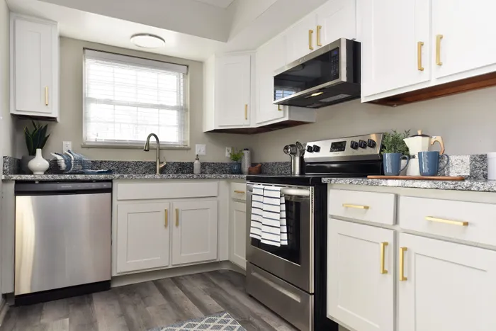 Contemporary kitchen with white cabinets, stainless steel appliances, and elegant granite countertops.