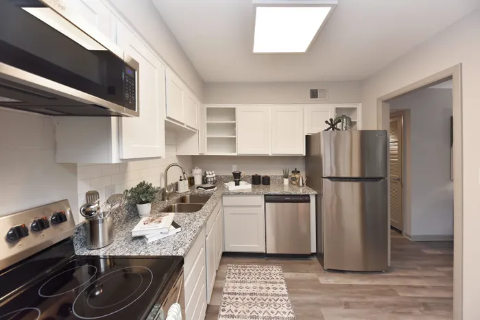 Chic kitchen with modern appliances, white cabinetry, and granite countertops.