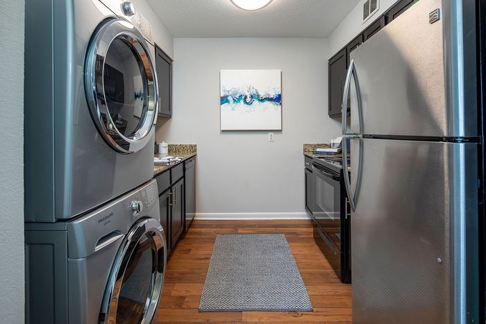 Chic kitchen featuring stainless steel appliances, granite countertops, and a convenient in-unit washer and dryer.