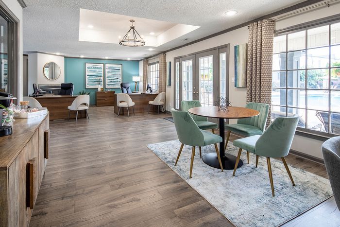 Chic office lobby with modern decor, featuring plush seating and large windows overlooking a pool.