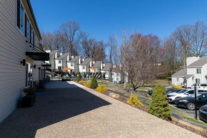 Charming townhouse community with modern architecture, nestled in a serene landscape with lush greenery and ample parking.