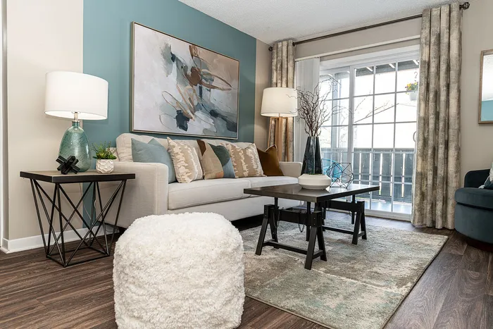 Elegant living room with modern decor, featuring a plush sofa, abstract art, and a bright window view, perfect for relaxation.