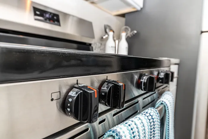 Sleek stainless steel range with modern knobs and stylish kitchen accents, perfect for culinary enthusiasts.