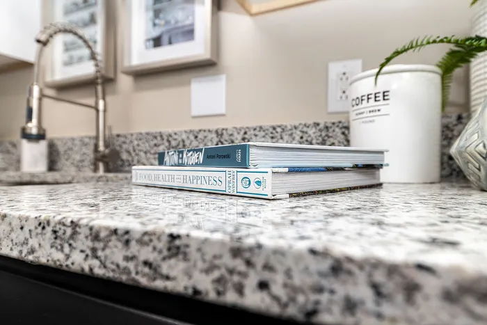 Elegant granite kitchen countertop with stylish decor including cookbooks and a chic coffee canister.