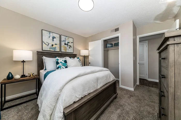 Charming bedroom with modern decor, featuring a cozy bed with stylish cushions, elegant wall art, and a soft carpeted floor for ultimate comfort.