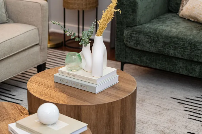 Elegant living room setup with a cozy green sofa, stylish wooden coffee table, and tasteful decorative accents.