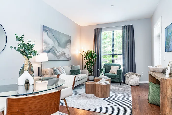 Inviting living room with chic decor, featuring a comfortable sofa, modern artwork, and a glass dining table for elegant dining.
