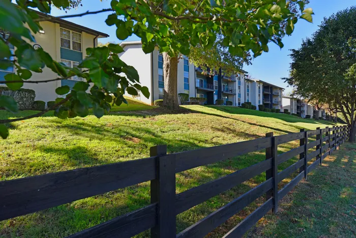 Charming apartment complex set amidst lush greenery, featuring spacious balconies and a serene atmosphere.
