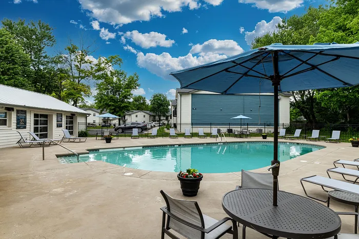 Inviting swimming pool area with sun loungers and shaded seating, perfect for relaxation on a sunny day.