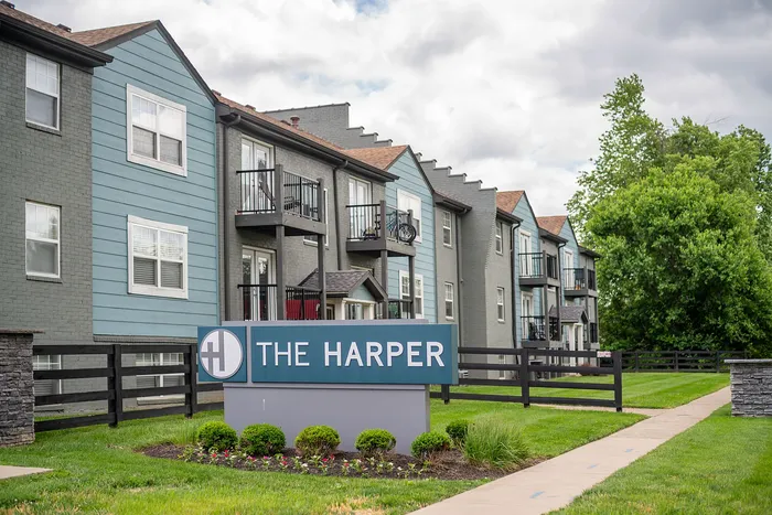 Modern apartment complex with charming balconies and lush green surroundings at The Harper.