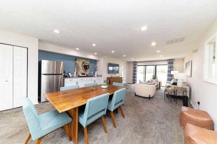 Contemporary open-concept living area with chic dining space, sleek stainless steel appliances, and inviting lounge, accentuated by bright natural light.
