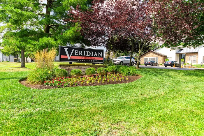 Beautifully landscaped entrance to Veridian of Lexington Apartments, featuring vibrant greenery and a welcoming atmosphere.