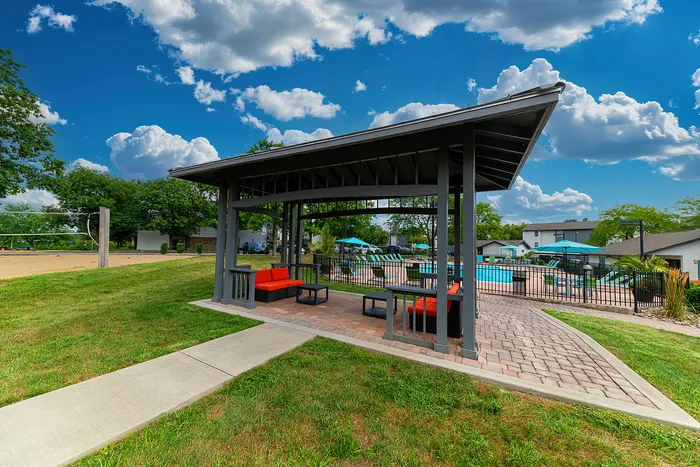 Charming outdoor pool area with vibrant seating and gazebo, ideal for relaxation and sunny leisure.