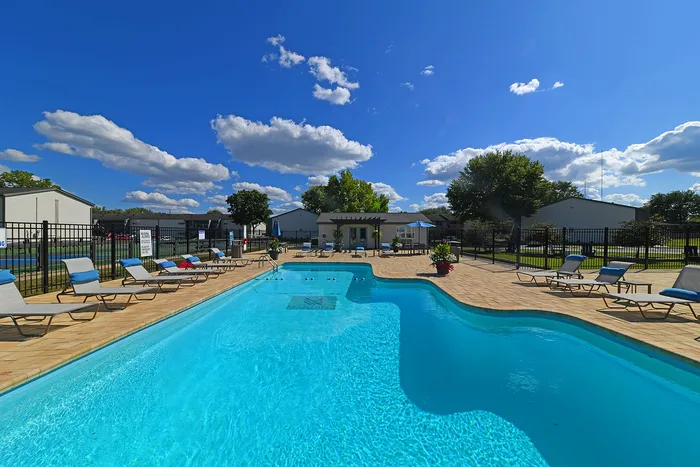 Inviting outdoor swimming pool area with sun loungers and a vibrant sky, perfect for relaxation and leisure.