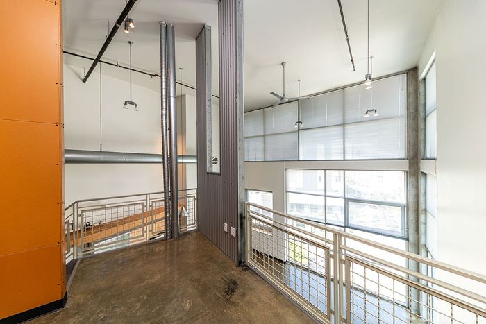 Modern industrial-style loft with high ceilings, large windows, and sleek metal accents.